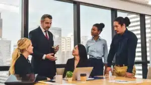 Image d'un manager qui échange avec son équipe dans un bureau.